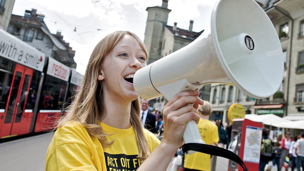 Eine junge Frau mit Megaphon in Bern