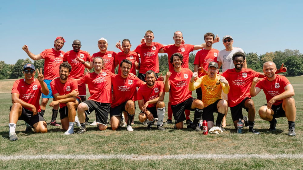 Les joueurs de l'IFCB posent tous ensemble après un tournoi en souriant et levant les bras.