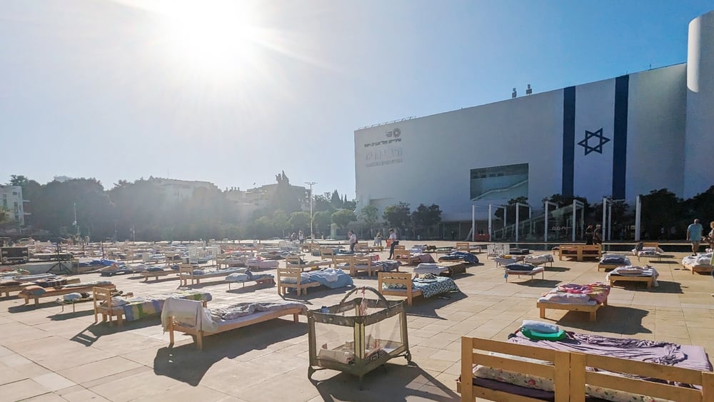 Die Installation «Empty Beds» (Leere Betten) des Künstlers Eran Webber war im November 2023 für mehrere Tage auf dem Habima-Platz in Tel Aviv-Jaffa zu sehen. Sie bestand aus mehr als 200 leeren Betten, die die Geiseln symbolisierten, die von der Hamas in Gaza festgehalten wurden, nachdem sie am 7. Oktober entführt worden waren. © Gil Naveh / Amnesty International