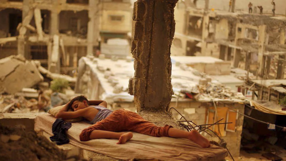 Knabe während eines Sandsturms in Gaza, September 2015. Immer noch sind viele Gebäude zerstört. © Suhaib Salem/Reuters