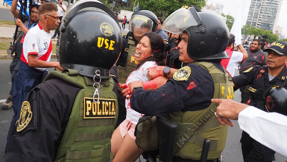 Eine Frau wird verhaftet, weil sie rote Farbe gegen die Polizei geworfen hat an einer Demonstration in Lima vom 3. Januar 2023 © IMAGO / ZUMA Wire / Carlos Garcia Granthon