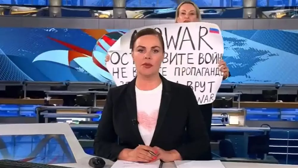 Am 14. März tauchte Marina Ovsiannikova hinter der Nachrichtensprecherin mit einem Plakat gegen den von Russland geführten Krieg auf. © Screenshot