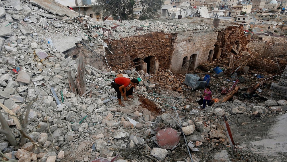 Zivilpersonen auf den Ruinen eines von russischen Kräften bombardierten Hauses in der Provinz Aleppo. © REUTERS/Ammar Abdullah