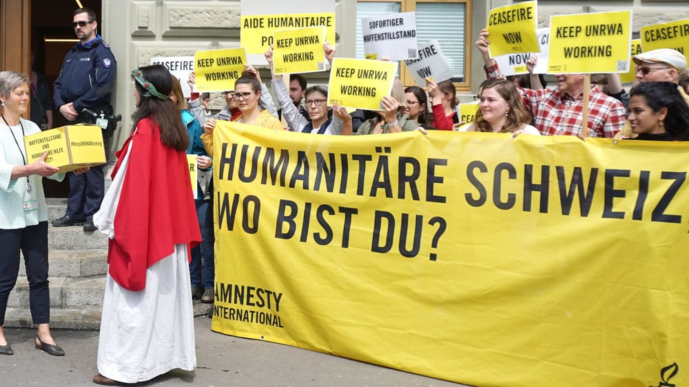 «Helvetia», die für das humanitäre Völkerrecht steht, übergibt die Unterschriften der Petition an die Bundeskanzlei. © Amnesty Schweiz / Weitere Fotos von der Übergabe bei Klick aufs Bild.