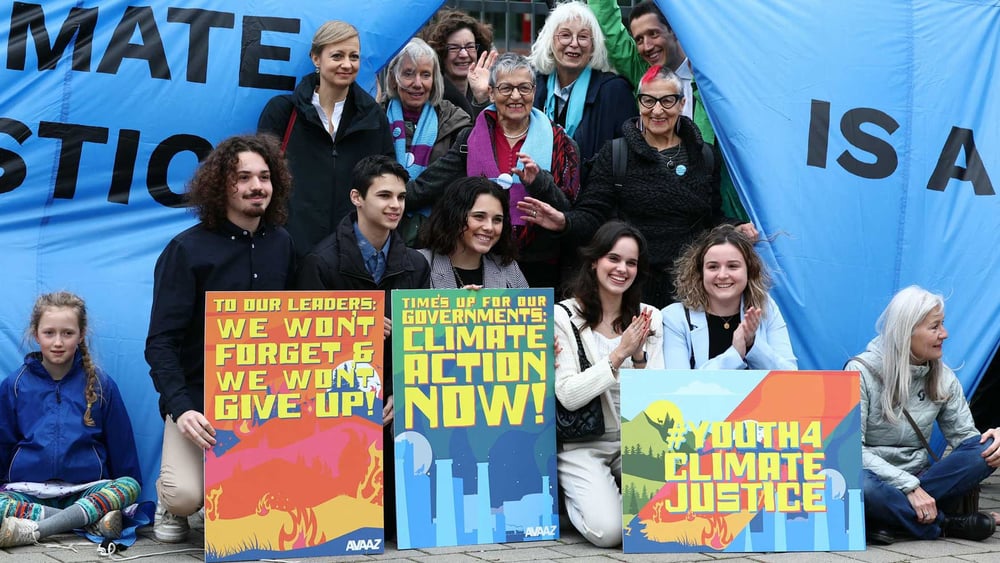 Klägerinnen und Klimaaktivist*innen warteten mit Plakaten auf die Entscheidung des Europäischen Gerichtshofs für Menschenrechte in drei verschiedenen Klimafällen. 9. April 2024, Strassburg (Frankreich) © AFP via Getty Images