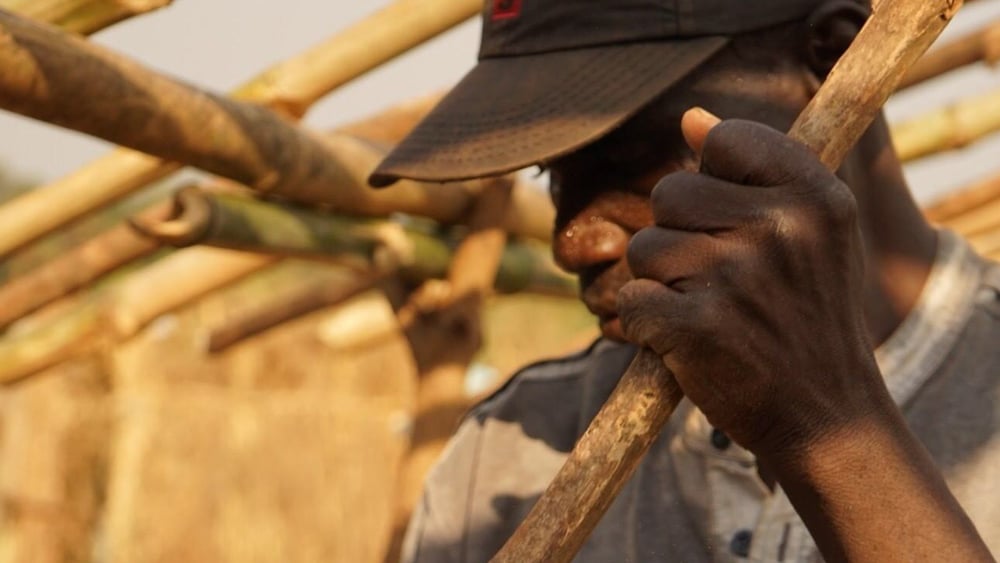 Ein ehemaliger Bewohner des Lagers für Vertriebene in Alindao, der sich in Bambari eine neue Unterkunft baut © Joanne Mariner/Amnesty International