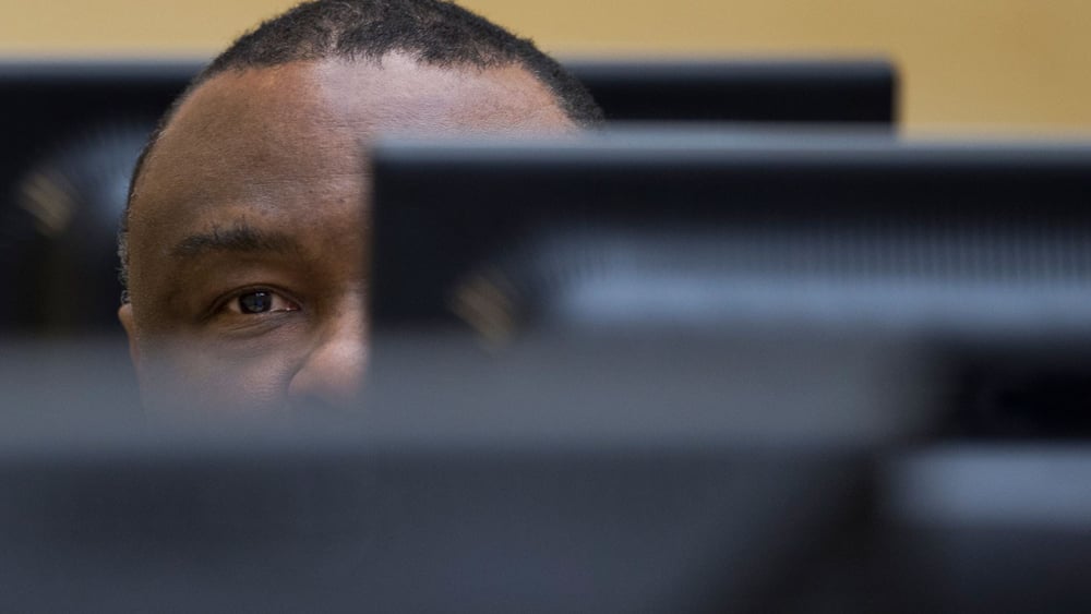 Den Haag, 27. November 2013: Der ehemalige kongolesische Präsident Jean-Pierre Bemba verbirgt zu Beginn seines Prozesses am ICC sein Gesicht vor den Reportern und Prozessbeobachterinnen. © Peter Dejong / AP Pool