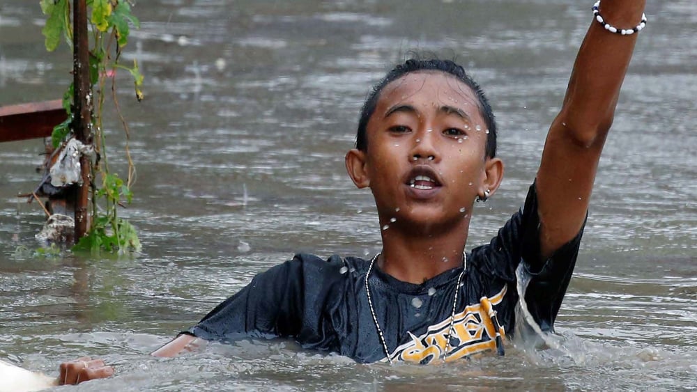 © Ein Junge auf der philippinischen Insel Luzon watet nach einem Sturm im Wasser. September 2017. © Reuters / Erik De Castro