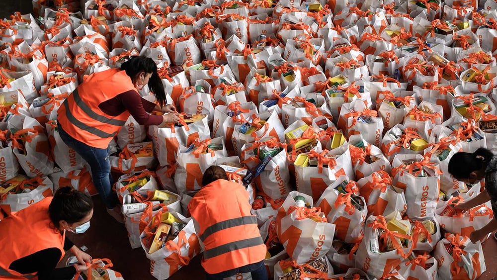 Freiwillige beim Vorbereiten der mit Lebensmitteln gefüllten Taschen. Genf im Mai 2020. Weitere Eindrücke von den Verteilaktionen bei Klick aufs Bild. © Fabrice Coffrini/AFP via Getty Images