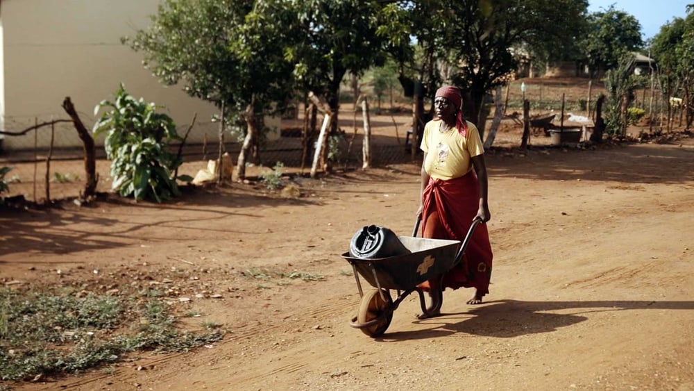 Sarah Makhubela ist mit ihrer Schubkarre auf dem Weg zum Wassertank. © Jasmin Sarwoko