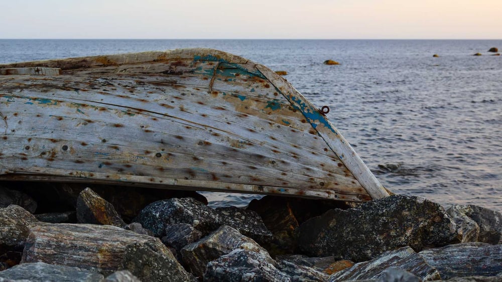 Nuara und ihr Baby verstecken sich unter einem umgekippten Boot, um nicht von der Küstenwache entdeckt zu werden. © imago images