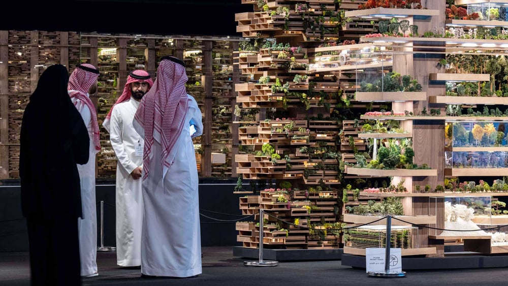 Besucher*innen betrachten an einer Ausstellung in Riad Modelle des Projekts The Line. © Balkis Press / ABACA / imago