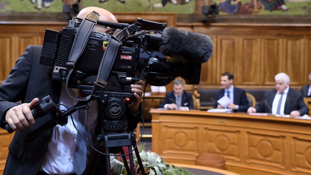Ein Kameramann filmt die Parlamentarier*innen während der Session. Eine ausgewogene Berichterstattung über die Schweizer Politik gehört zum Auftrag der SRG. © Anthony Anex / KEYSTONE