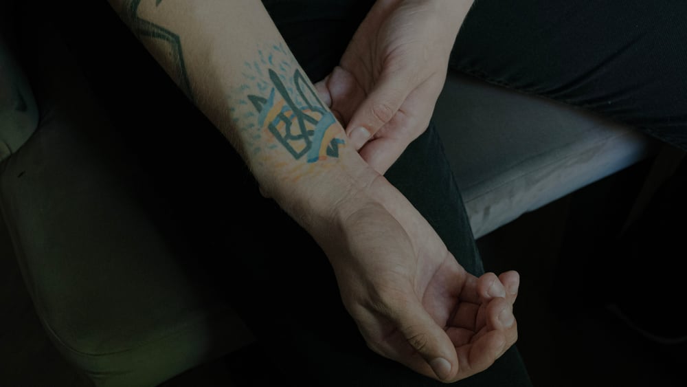 Ein Unterarm mit einem Tatoo, das den ukrainischen Dreizack zeigt