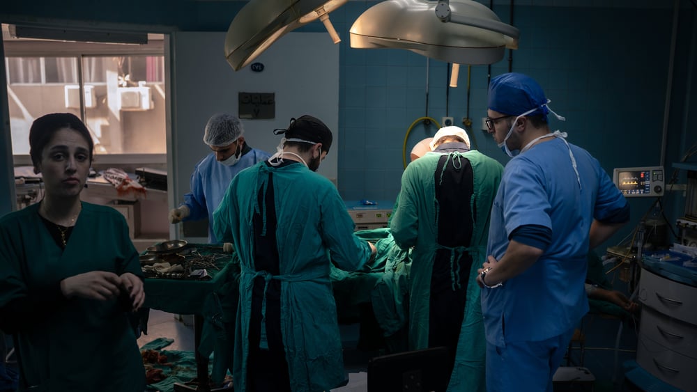 Im Operationssaal beugen sich sich die Ärzt*innen und weiteres Personal über den Operationstisch