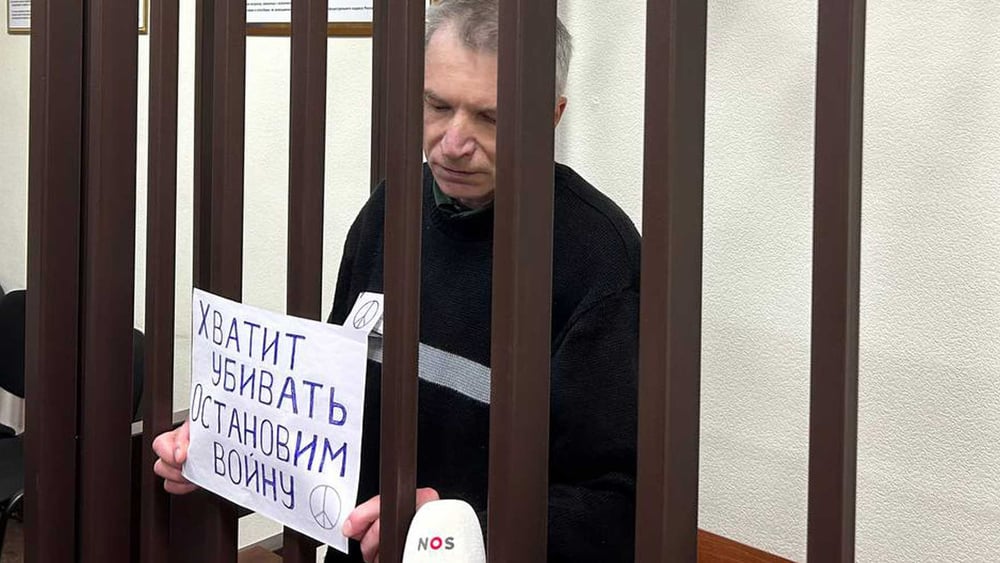 Aleksei Gorinow im Gerichtssaal mit einem Antikriegsplakat und einem Peace-Zeichen auf seinem Namensschild an seiner Uniform © Mediazona