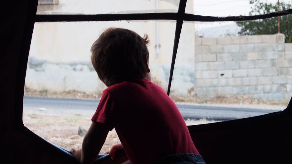 Ein Kind schaut aus einem Zelt bei Killis © Amnesty International