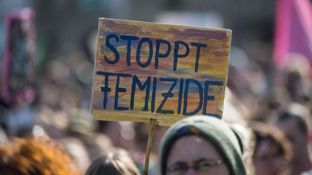 Ein Schild mit dem Slogan "Stoppt Femizide"