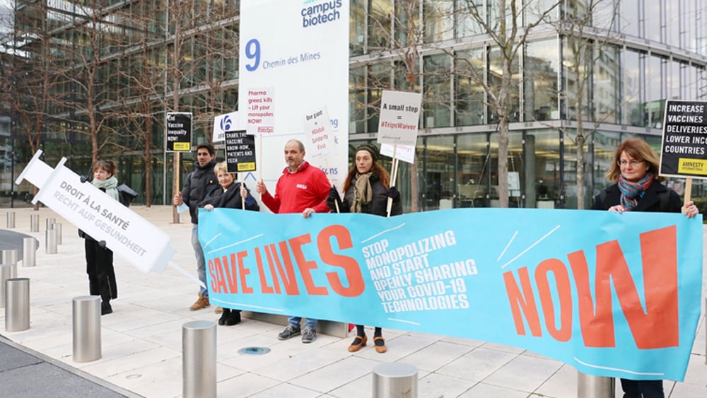 Alliance Sud, Public Eye und Amnesty Schweiz demonstrierten am 30. November 2021 gemeinsam vor dem Hauptsitz der IFPMA (International Federation of Pharmaceutical Manufacturers & Associations), in Genf für einen Verzicht auf das Patent für Covid-19-Impfstoffe.
