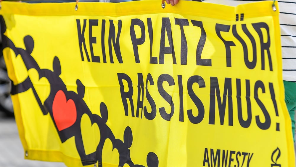 Ein Amnesty-Transparent auf dem steht: Kein Platz für Rassismus