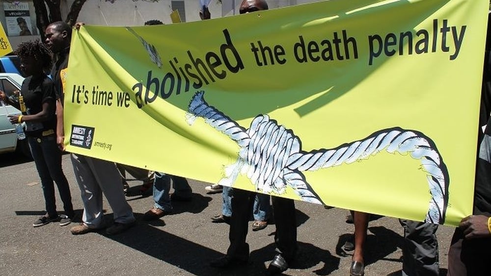 Aktivist*innen von Amnesty International Simbabwe auf einem Marsch mit einem Transparent "It's time we abolished death penalty"