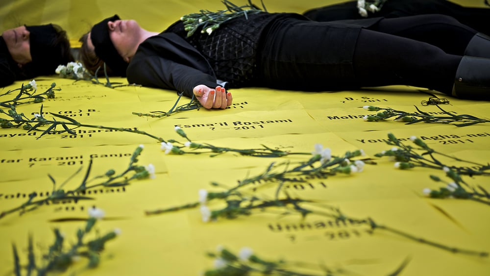 In einer Aktion gegen die Todesstrafe von Amnesty Schweiz liegen Menschen inmitten von Rosen auf dem Boden.