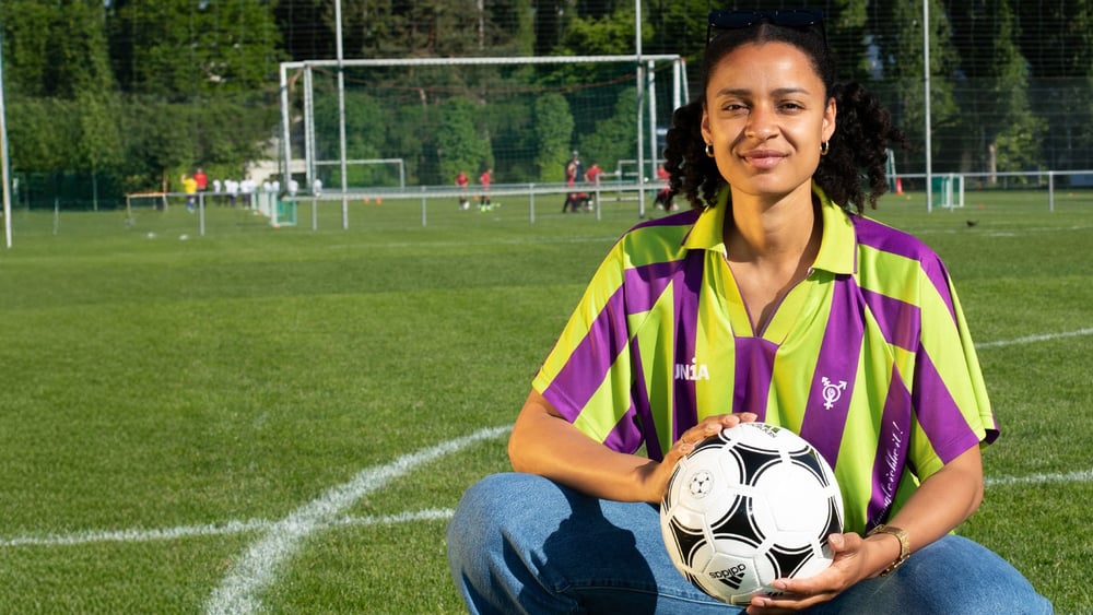 Die Fussballerin, Politikerin und Podcasterin Sarah Akanji ist Vorstandsmitglied von Fussball kann mehr. Auf dem Bild präsentiert sie das EMpower-Trikot. © David Jäggi