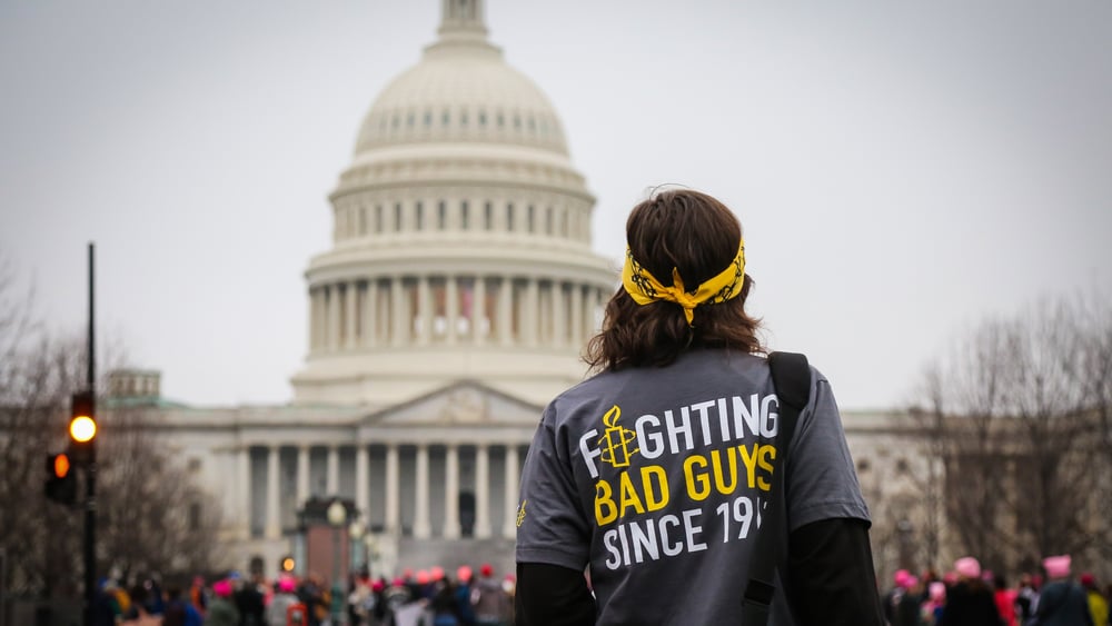 Ein junger Mann mit Stirnband vor dem Capitol in Washington,  auf seinem T-Shirt steht "Figthing Bad Gays since 19.." (der Rest der Jahreszahl ist abgedeckt