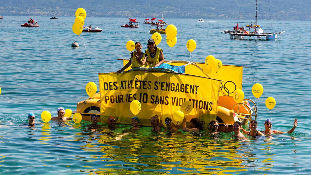 Die Profi-SchwimmerInnen vor dem Amnesty-Pedalo «Die AthletInnen engagieren sich für Olympische Spiele ohne Menschenrechtsverletzungen» © P-A Cordey