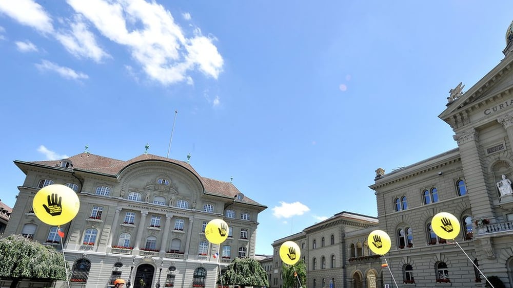 La place fédérale avec des ballons jaunes Amnesty.