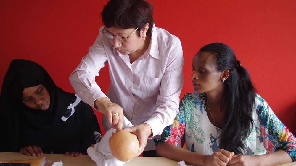 Iffrah et Genet écoutent attentivement les conseils de Silvia, la sage-femme qui co-anime l’atelier «devenir maman dans le canton de Neuchâtel». © Julie Jeannet
