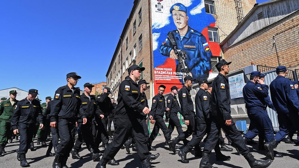 A Krasnoïarsk, en Russie, des soldats passent devant un graffiti à la mémoire du parachutiste russe Vladislav Razumov, tué pendant la guerre en Ukraine.© IMAGO/SNA/Ilya Naymushin