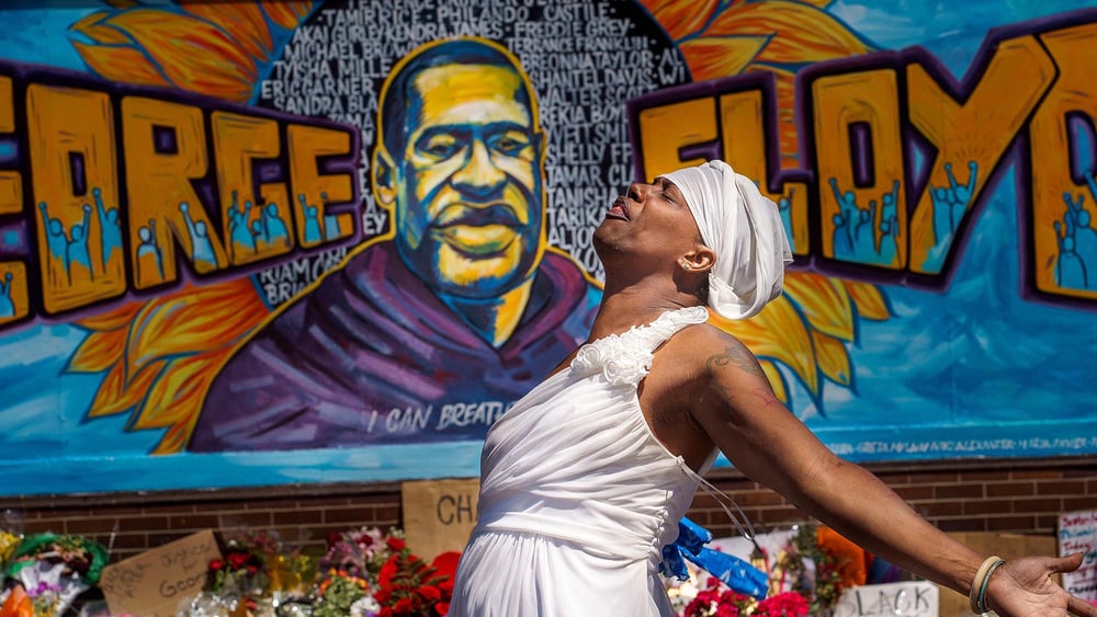 Lors d’une cérémonie à la mémoire de George Floyd en 2020, une participante exprime sa tristesse devant l’un des nombreux graffitis représentant le portrait de cet homme afro-américain, mort asphyxié sous le genou d’un policier lors de son arrestation. © Kerem Yucel/Keystone/AFP