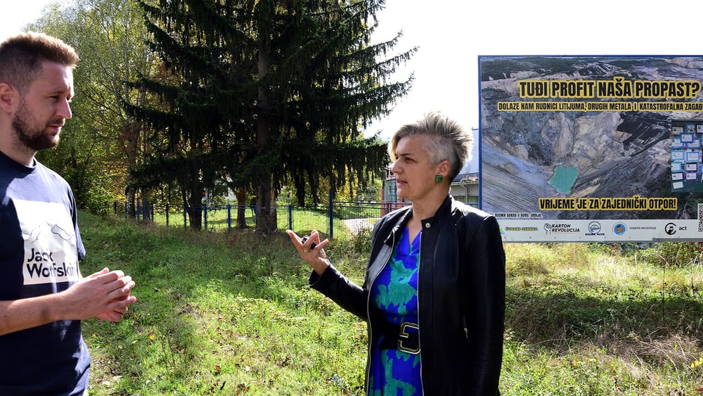 Andrijana Pekic et Adi Selman à l’entrée du village de Lopare devant une affiche contre le projet d’exploitation de lithium. © Sead Husic