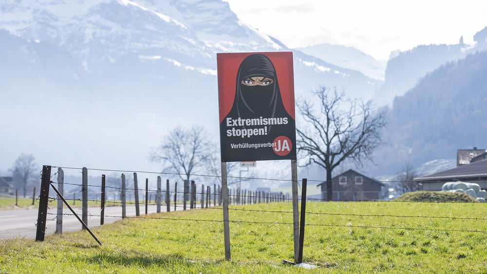 Une affiche de l’initiative populaire « Oui à l’interdiction de se dissimuler le visage » en 2021 dans le canton de Nidwald. © Urs Flueeler/KEYSTONE