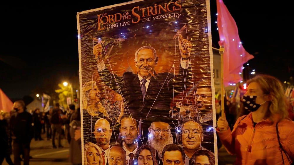 Des Israélien·ne·x·s manifestent contre Benjamin Netanyahu à Jérusalem à la veille de sa comparution devant un tribunal, en février 2021, pour répondre aux accusations de corruption portées contre lui. L’audience sera reportée en raison de la pandémie. © Menahem Kahana/KEYSTONE/AFP