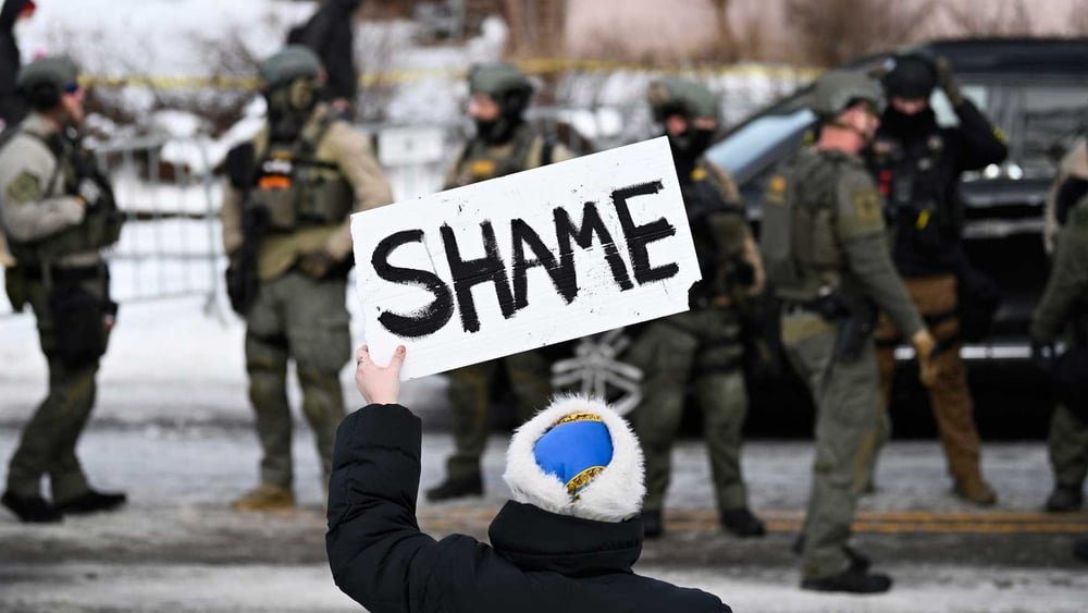 Une personne brandit une pancarte où l'on peut lire «Honte» en réaction au meurtre d'une femme par un agent de la police fédérale dans le sud de Minneapolis © Stephen Maturen/Getty Images
