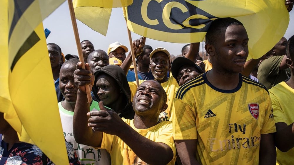 Les partisan·ne·x·s du chef de l'opposition de la Citizens Coalition for Change (CCC), Nelson Chamisa, brandissent le drapeau de leur parti lors de leur dernier rassemblement électoral à Harare, le 21 août 2023. © AFP via Getty Images