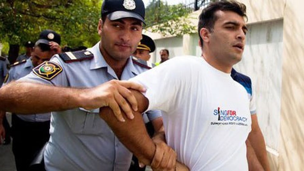 Des policiers arrêtent le défenseur des droits humains Rasul Jafarov. Il s’était engagé pour la démocratie dans son pays. Bakou, juin 2014. © RFE