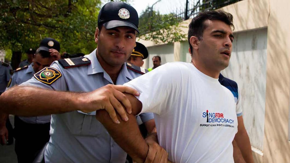 Des policiers arrêtent le défenseur des droits humains Rasul Jafarov. Il s’était engagé pour la démocratie dans son pays. Bakou, juin 2014. © RFE