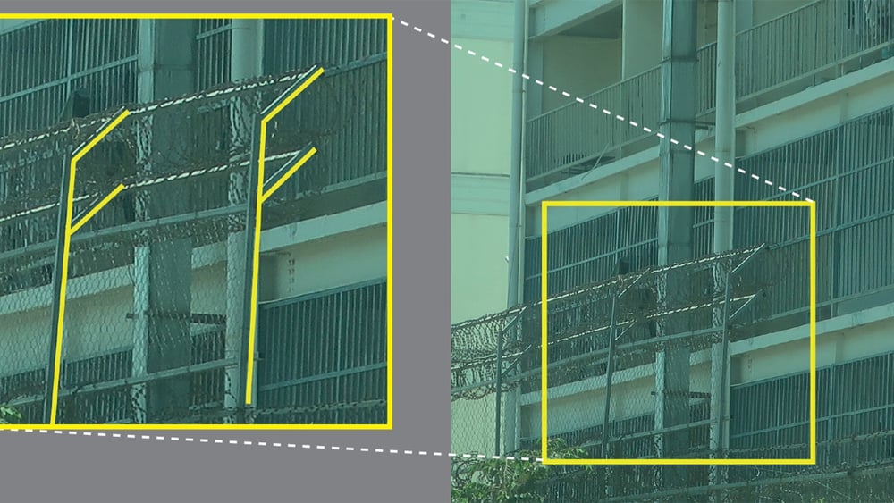 Le mur d'enceinte de l'un des centres, surélevé et incliné vers l'intérieur et cerclé de fil barbelé pour empêcher les personnes de l'escalader. © Amnesty International