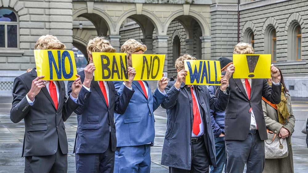 Des membres d'Amnesty Suisse déguisés en Donald Trump protestent contre le décret anti-migration à Berne. © Amnesty International