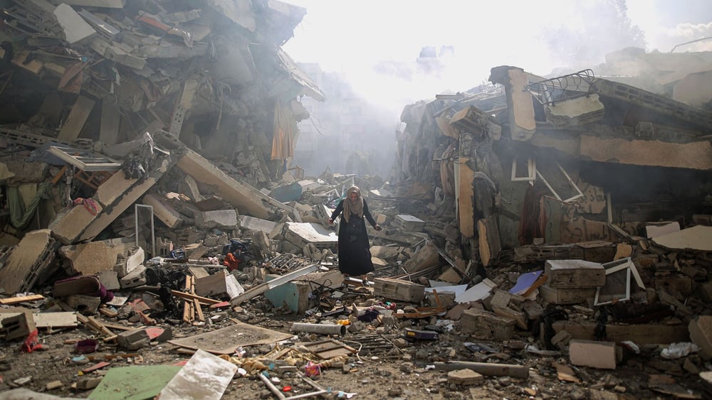 Une Palestinienne parmi les débris d'immeubles d'habitation dans le quartier d'al-Zahra, dans la bande de Gaza, après des frappes aériennes israéliennes, le 19 octobre 2023 . © Mustafa Hassona/Anadolu via Getty Images | CLIQUEZ SUR L'IMAGE POUR VOIR LA GALLERIE PHOTO