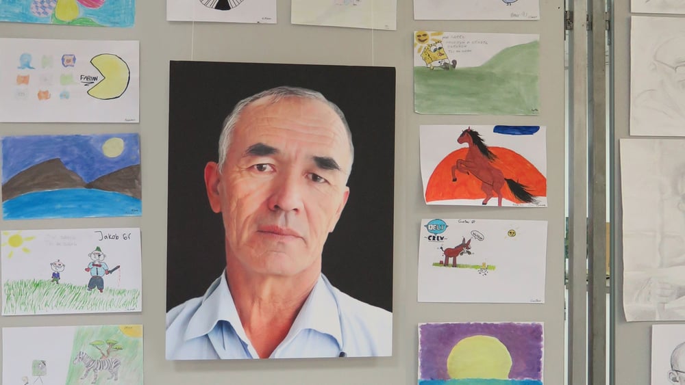 Photo d'Azimjan Askarov entourée de dessins de jeunes activistes © Amnesty International