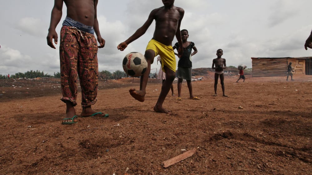 Des enfants jouent au football au bord de l'eau de Timber, près du front de mer de Bundu, à Port Harcourt, au Nigeria, en avril 2011.  © George Osodi / Amnesty International