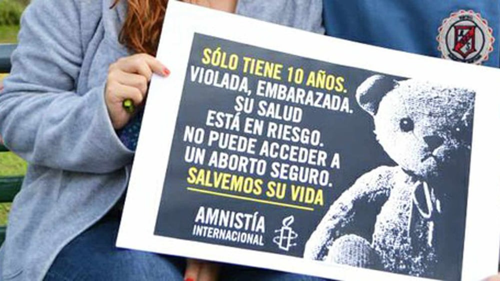 Action organisée en Argentine par des membres d'Amnesty: "Elle n'a que 10 ans. Violée, mise enceinte, sa santé est menacée. Elle n'a pas accès à une interruption de grossesse sûre. Sauvons-la." | © AI
