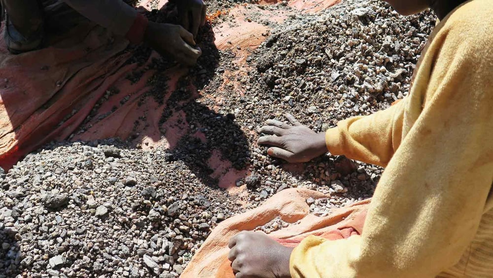 Charles 13 ans, trie des pierres contenant du cobalt avec son père, dans la province du Katanga, République Démocratique du Congo. Mai 2015. © Amnesty International - Afrewatch