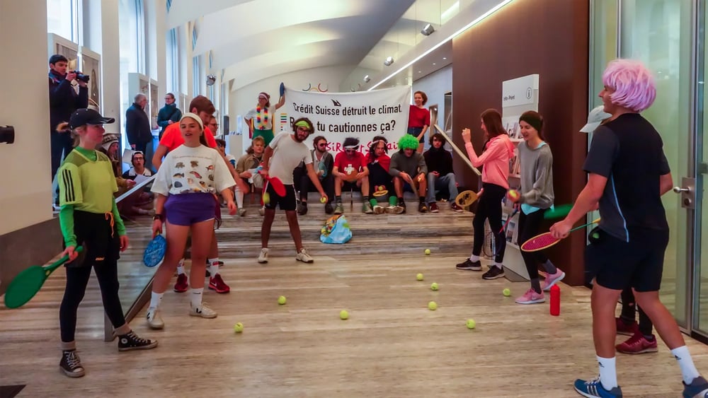 Des jeunes activistes jouent au tennis dans les locaux d'une banque à Lausanne.