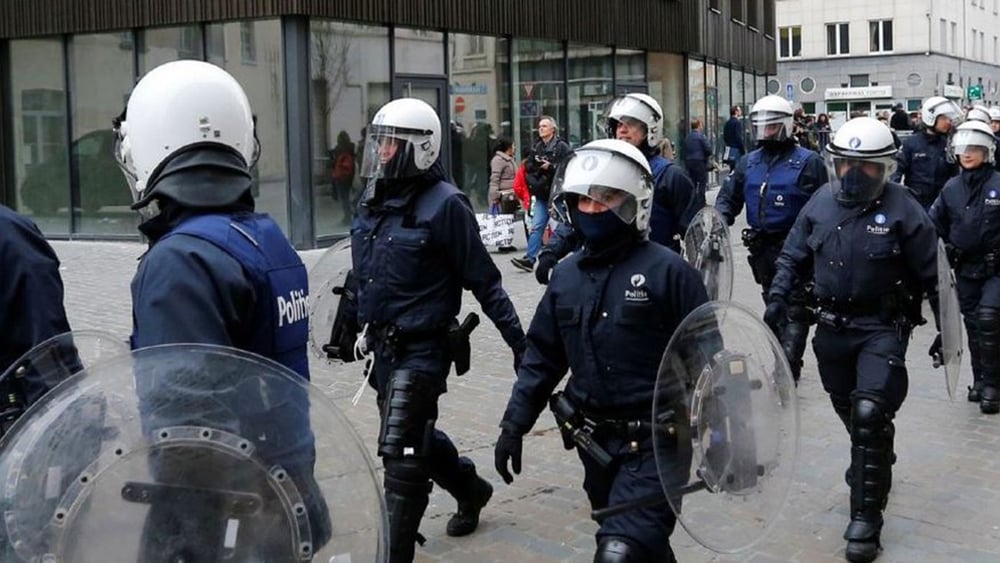 Des policiers belges en tenue anti-émeute en marche vers la commune de Molenbeek à Bruxelles, Belgique, 2 avril 2016. © REUTERS/Yves Herman