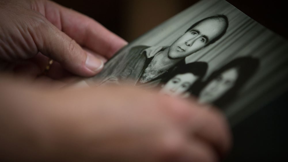 La femme d'un activiste politique disparu en 2013 tenant une photo de sa famille. © Amnesty International - Mark Esplin